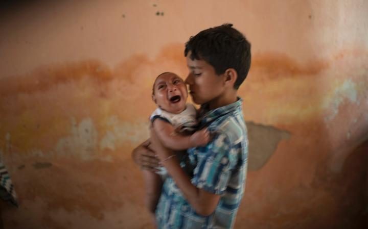 10-year-old Elison nurses his 2-month-old brother Jose Wesley 